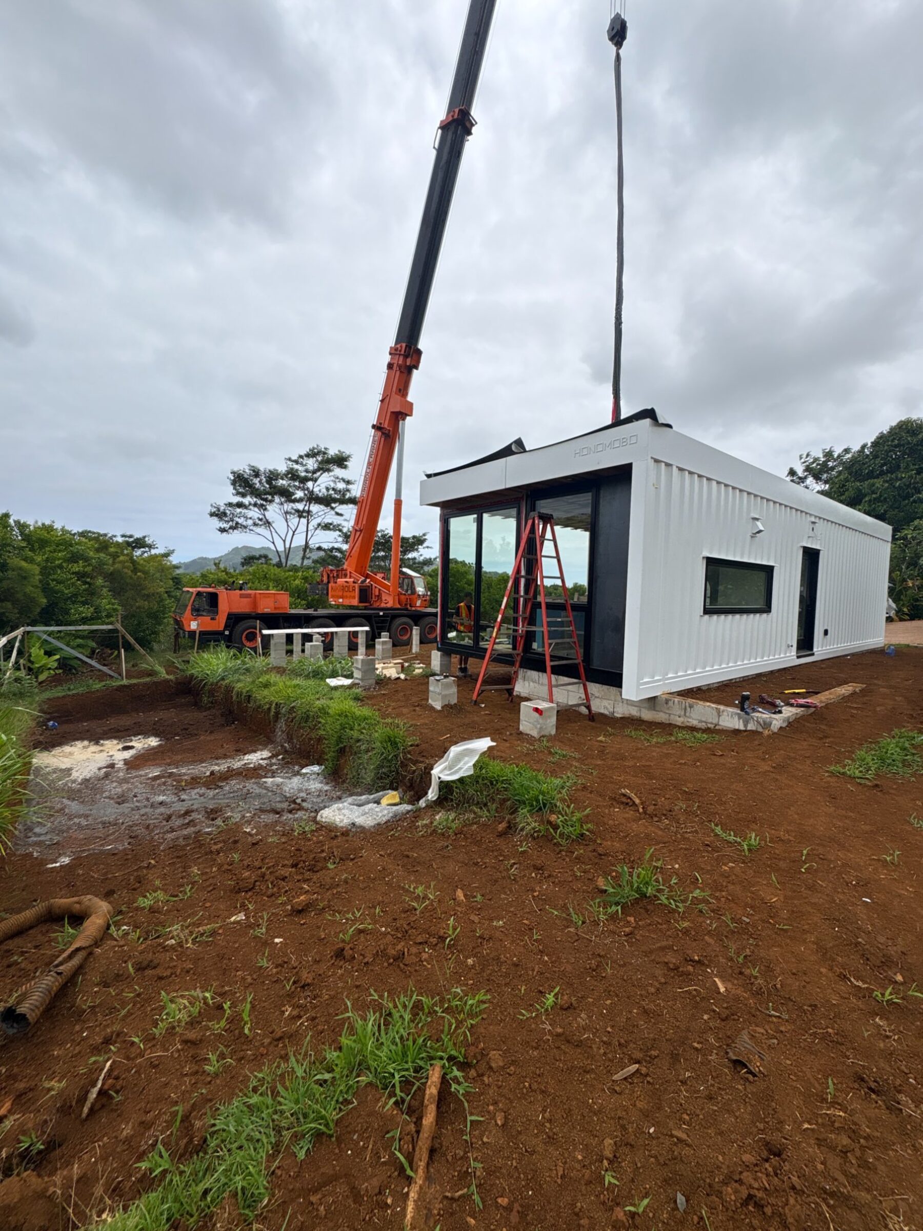 Crane installing Honomobo HO4 on Kauai foundation